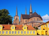 Der Dom zu Roskilde mit gelben Häusern im Vordergrund