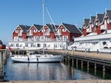 Ferienwohnungen und ein Segelschiff im Hafen von Bagenkop auf Langeland
