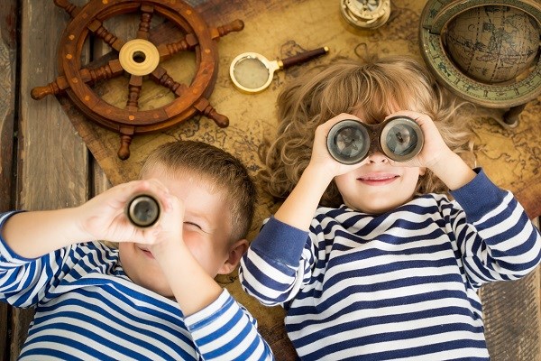 2 Kinder mit Fernglas im maritimen Ringelshirt im Sand