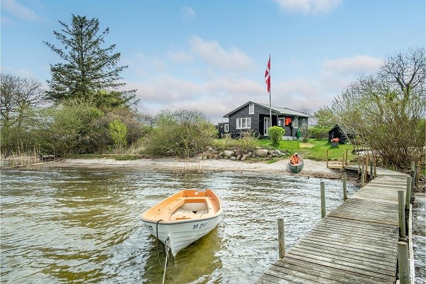 Ein kleines schwarzes Ferienhaus am See in Dänemark 