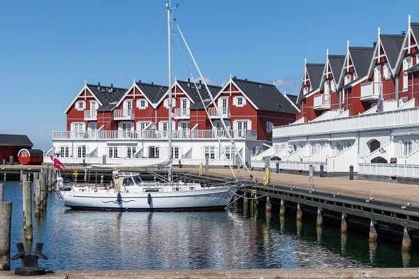 Ferienwohnungen und ein Segelschiff im Hafen von Bagenkop auf Langeland