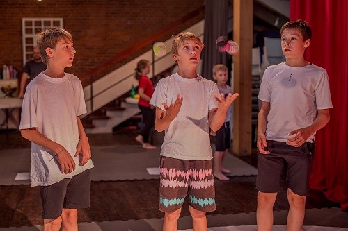 3 Jungen beim Jonglieren im Sommerzirkus