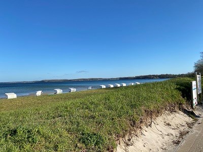 Strandkörbe hinter Düne vorm blauen Meer