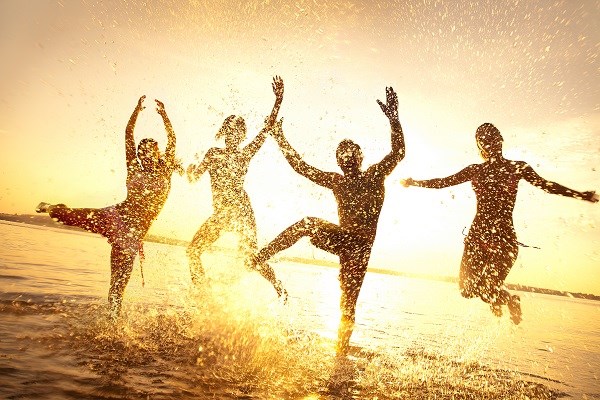 Vor Freude springen Leute im Wasser am Strand