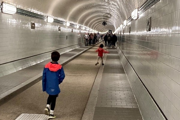 Zwei Kinder, die durch den Elbtunnel in Hamburg laufen