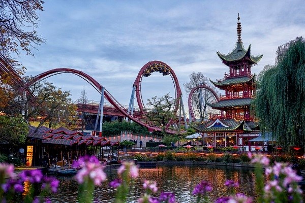 Der Achterbahn „Dämon“ und der Japanische Turm im Tivoli am Abend