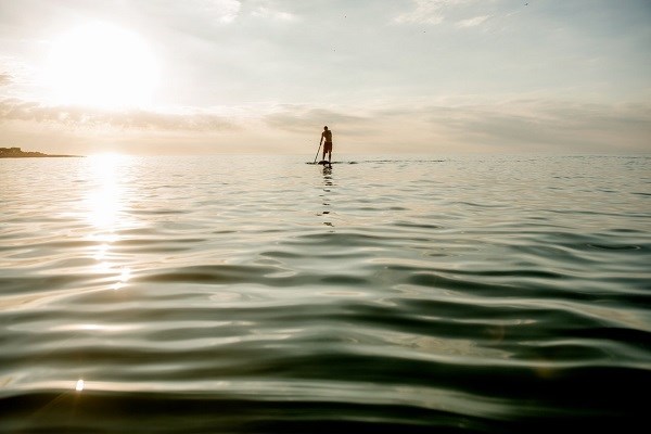 Ein männlicher Surfer auf einem SUP-Board in Nordjütland