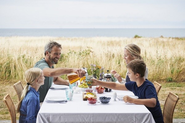 Eine Familie frühstückt auf der Terrasse eines Ferienhauses in Nysted auf Lolland