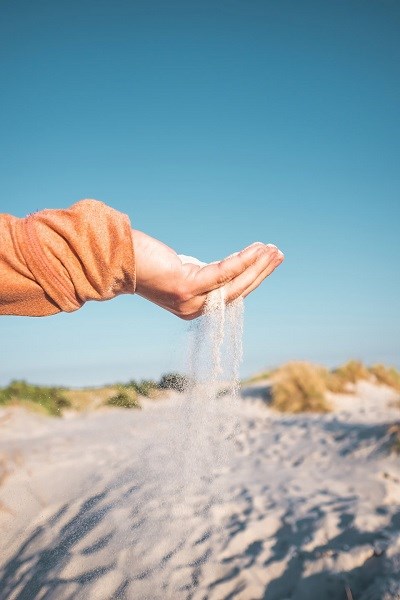 Eine Hand voller Sand am Dueodde-Strand auf Bornholm