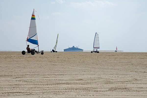 Strandsegler am Strand von Römö mit der FRS Syltfähre im Hintergrund