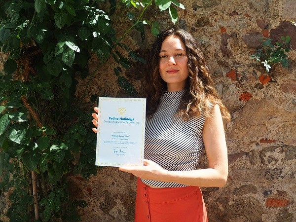 Stipendiatin Ricarda-Laura mit ihrem Feline Holidays Global Engagement Scholarship Zertifikat