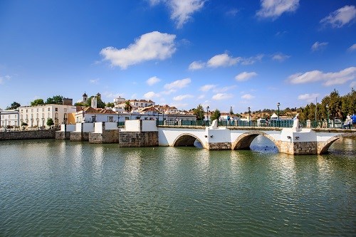 Brücke in Tavira mit Fluss und blauem Himmel 